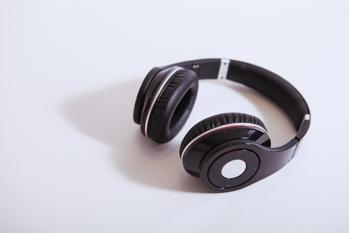 Sleek black over-ear headphones with cushioned pads resting on a white surface.